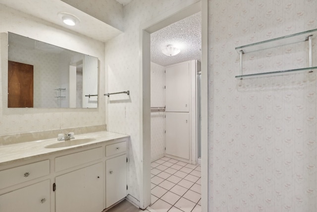 bathroom with vanity, tile patterned floors, and a textured ceiling