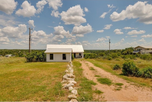 25633 Pedernales Point Dr, Spicewood, TX 78669 - view of front of property featuring driveway, a metal roof, a front yard, and an outdoor structure