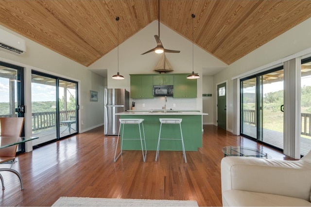 kitchen featuring backsplash, green cabinets, stainless steel fridge, dark wood-type flooring, and a breakfast bar