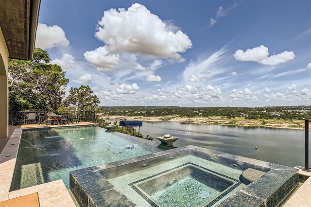 view of pool featuring a water view and an in ground hot tub