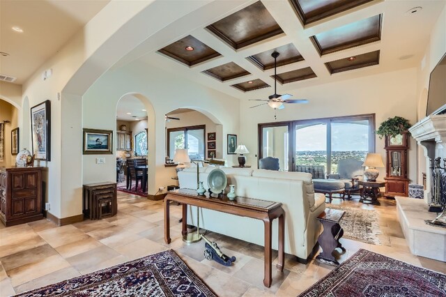 living room with coffered ceiling, a wealth of natural light, light tile patterned floors, and beamed ceiling