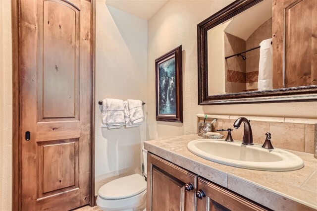 bathroom featuring curtained shower, toilet, and vanity