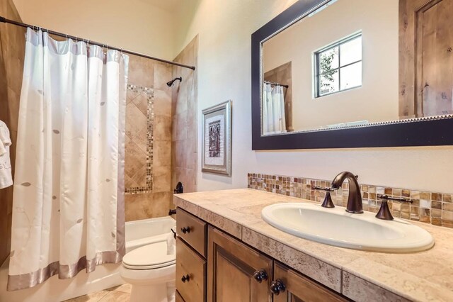 full bathroom with tile patterned floors, shower / bathtub combination with curtain, toilet, tasteful backsplash, and vanity