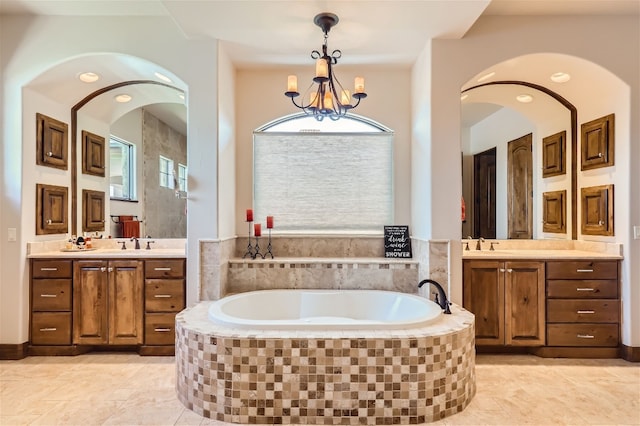 bathroom featuring a chandelier, vanity, tile patterned floors, and a relaxing tiled tub