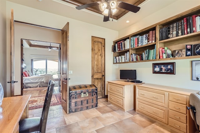 home office with a raised ceiling, light tile patterned floors, and ceiling fan