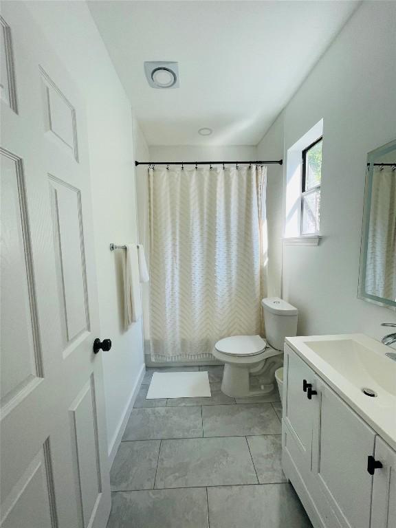 bathroom with vanity, a shower with shower curtain, and toilet