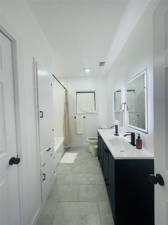 full bathroom with shower / tub combo with curtain, vanity, toilet, and tile patterned flooring