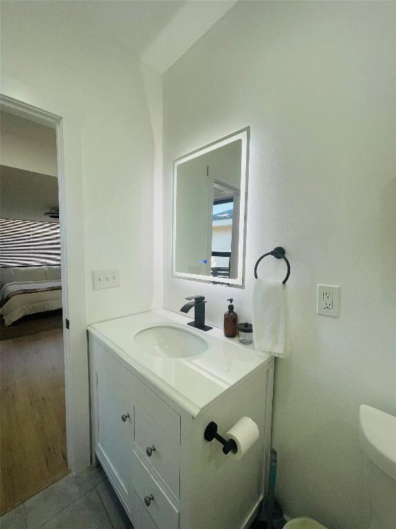 bathroom featuring vanity, tile patterned flooring, and toilet