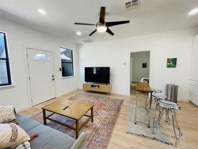 living room featuring ceiling fan and light hardwood / wood-style flooring