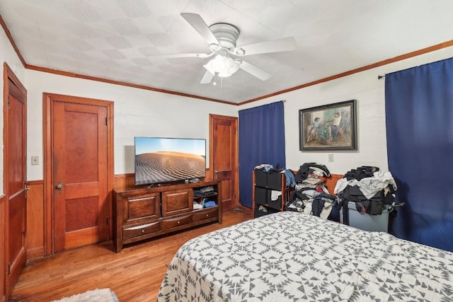 bedroom with ceiling fan, crown molding, and light wood-type flooring