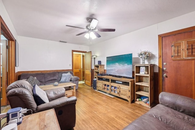 living room with light hardwood / wood-style flooring and ceiling fan