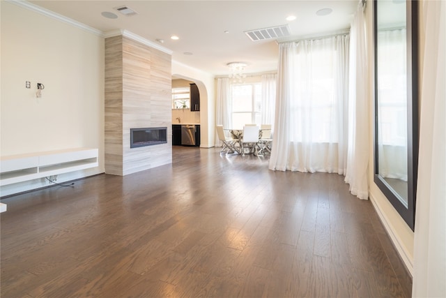 unfurnished living room with a tile fireplace, dark hardwood / wood-style floors, and ornamental molding