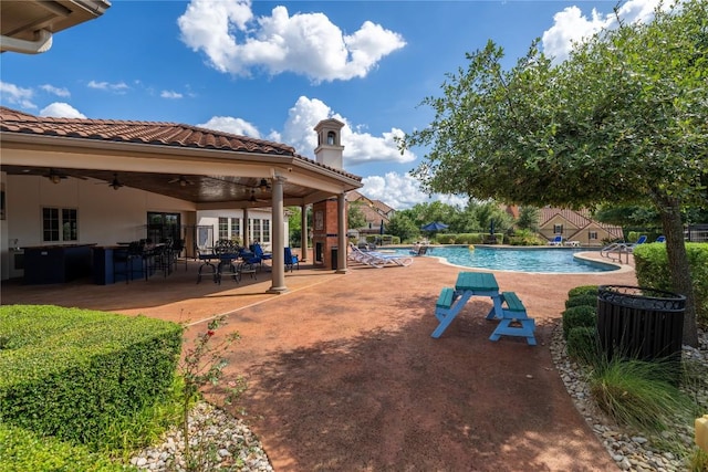 view of swimming pool with ceiling fan and a patio area