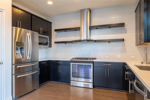 kitchen featuring decorative backsplash, appliances with stainless steel finishes, dark hardwood / wood-style flooring, and wall chimney exhaust hood