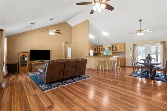 living room with high vaulted ceiling, ceiling fan, and hardwood / wood-style floors