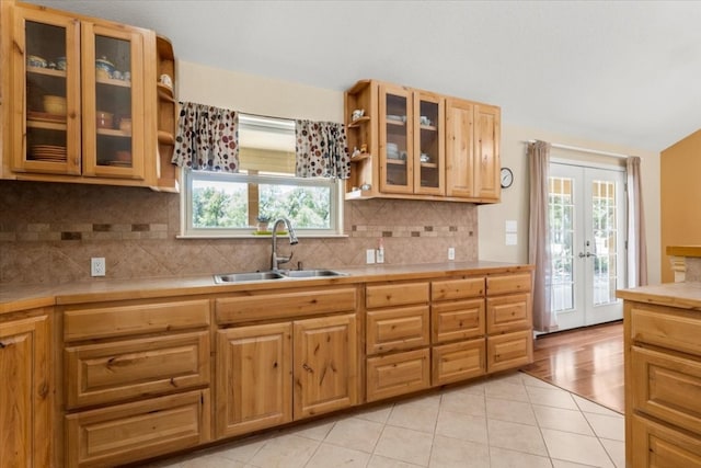 kitchen with light hardwood / wood-style floors, sink, a wealth of natural light, and decorative backsplash