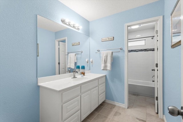 bathroom with tiled shower / bath combo, vanity, and tile patterned floors