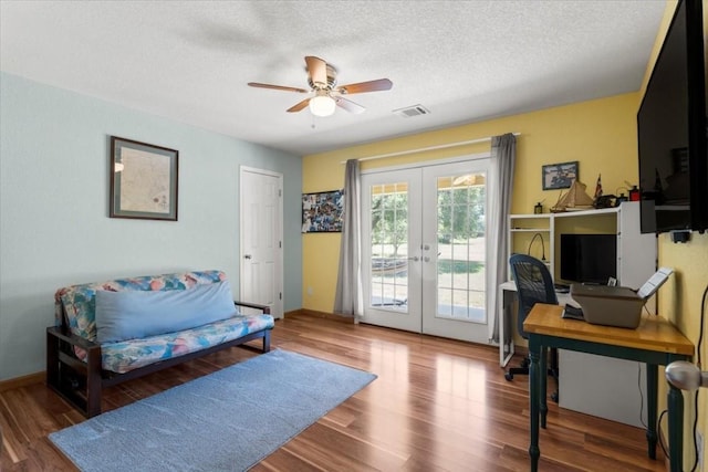 interior space with french doors, visible vents, a ceiling fan, a textured ceiling, and wood finished floors