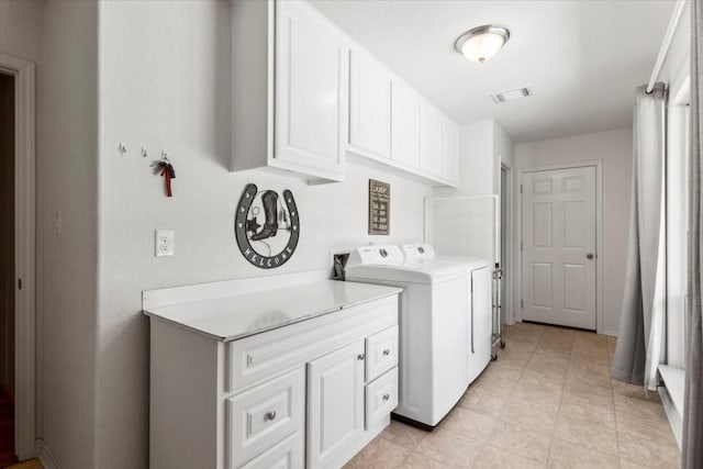 laundry area featuring cabinet space, visible vents, and washing machine and clothes dryer