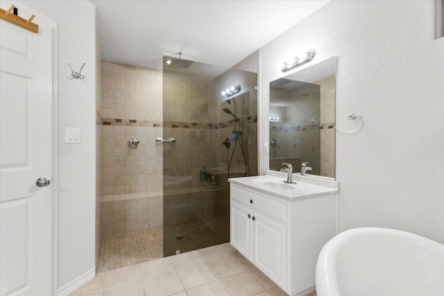 bathroom with tiled shower, tile patterned flooring, and vanity