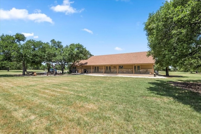 rear view of property with a yard and a patio area