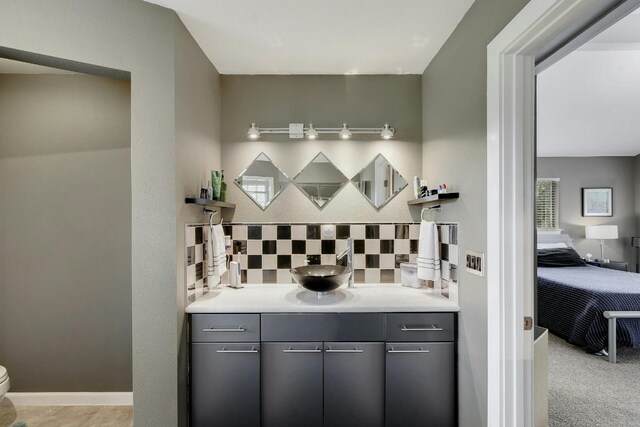 bar featuring gray cabinetry, light carpet, and backsplash