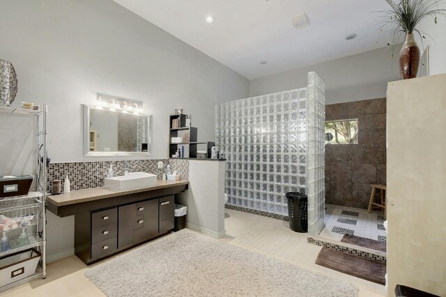 bathroom with vanity, decorative backsplash, tile walls, and tile patterned flooring