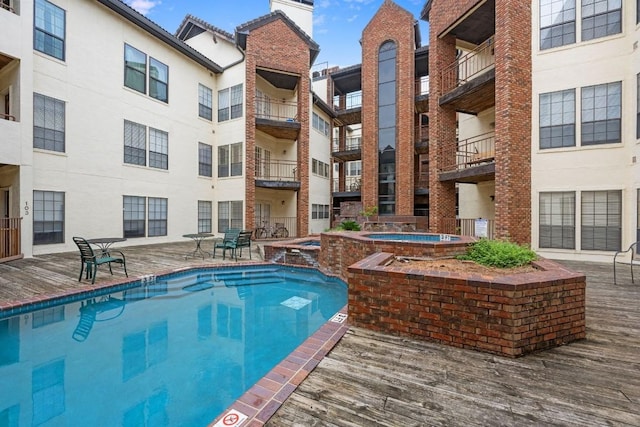 view of pool with a hot tub