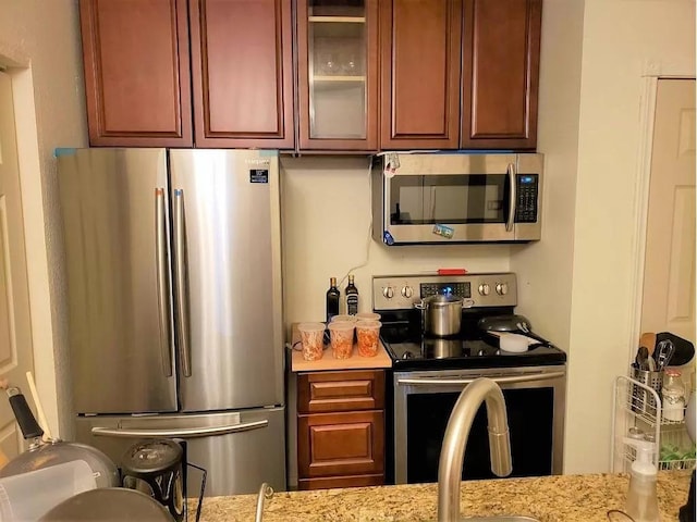 kitchen featuring light stone countertops and appliances with stainless steel finishes