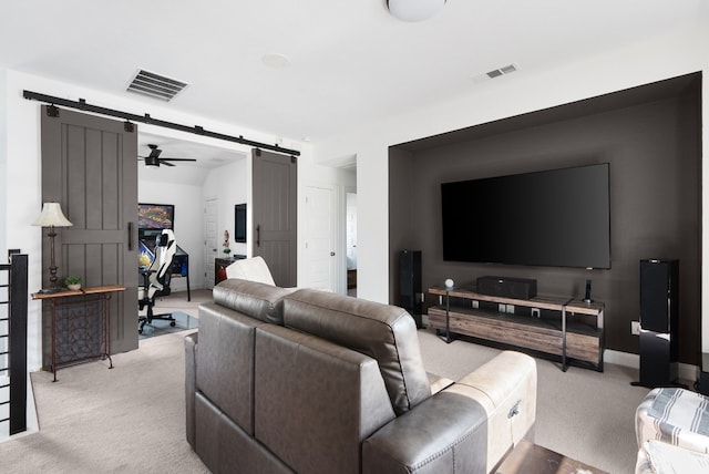 carpeted living room featuring a barn door and ceiling fan