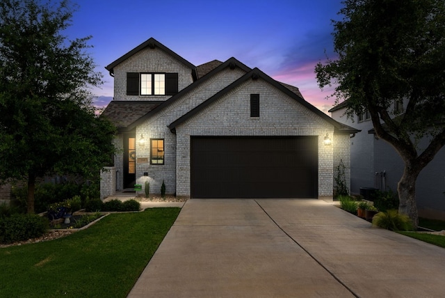 view of front of house with a garage and a yard