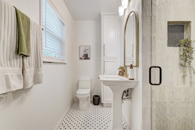 bathroom featuring tile patterned floors, toilet, and an enclosed shower