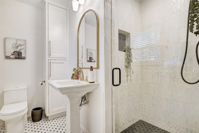 bathroom with tile patterned flooring, toilet, and a shower with shower door