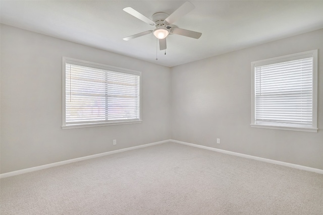 empty room with carpet floors, a wealth of natural light, and ceiling fan