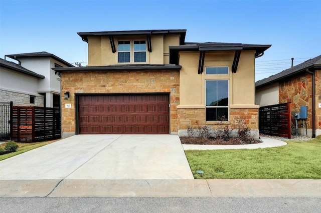 prairie-style home featuring a garage and a front lawn