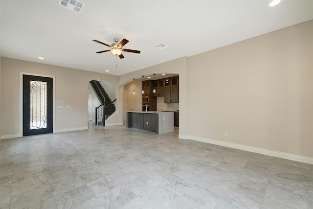 unfurnished living room featuring light tile patterned flooring and ceiling fan