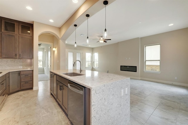 kitchen with sink, stainless steel dishwasher, light tile patterned floors, and plenty of natural light