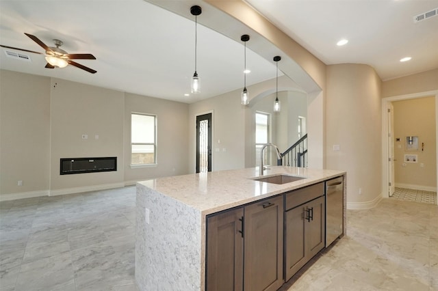 kitchen featuring light tile patterned flooring, sink, pendant lighting, and a kitchen island with sink