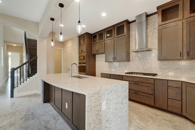 kitchen with sink, light tile patterned floors, tasteful backsplash, and wall chimney range hood