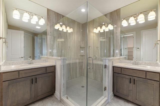 bathroom with a shower with shower door, tile patterned floors, and dual vanity