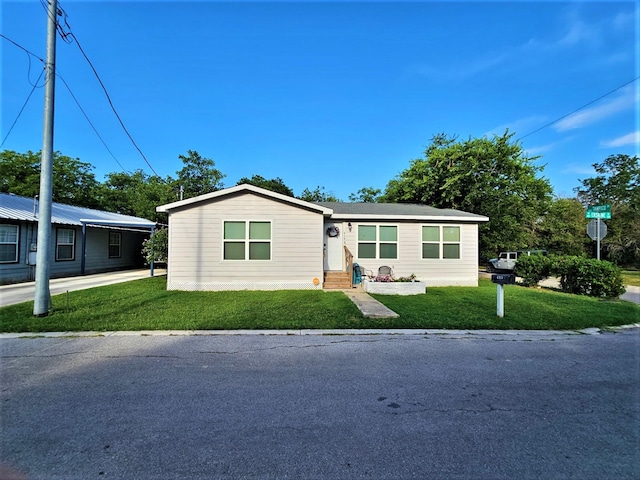 manufactured / mobile home featuring a front yard and entry steps