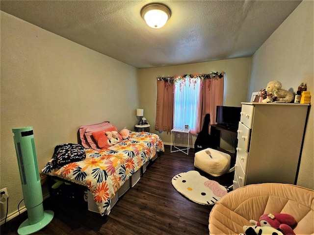 bedroom with dark hardwood / wood-style flooring and a textured ceiling