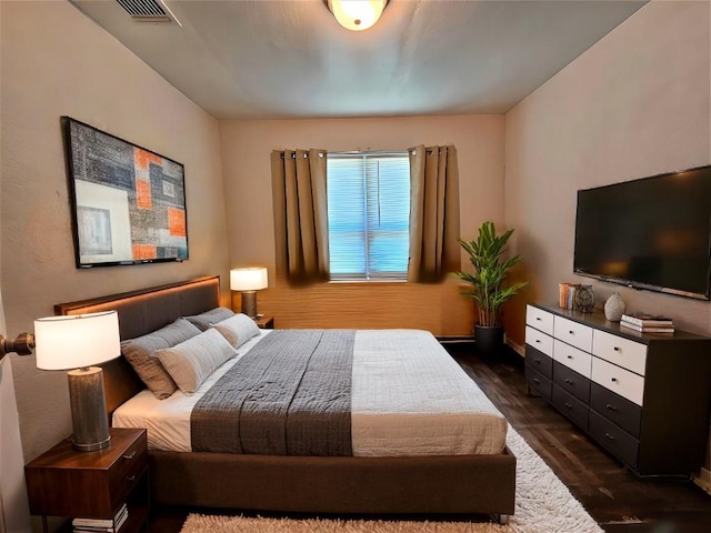 bedroom with dark wood finished floors and visible vents