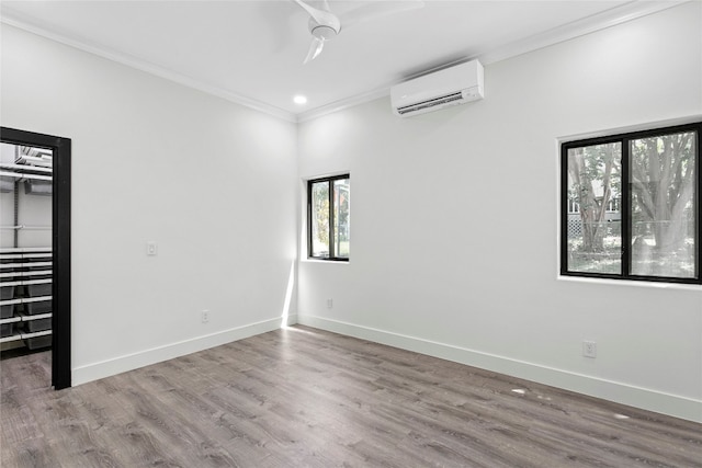 unfurnished room with hardwood / wood-style floors, ceiling fan, ornamental molding, and a wall mounted AC