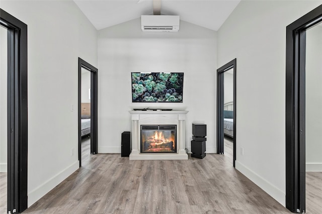5110 Sioux Ln, Austin, TX 78734 - unfurnished living room featuring a glass covered fireplace, wood finished floors, a wall mounted air conditioner, and high vaulted ceiling
