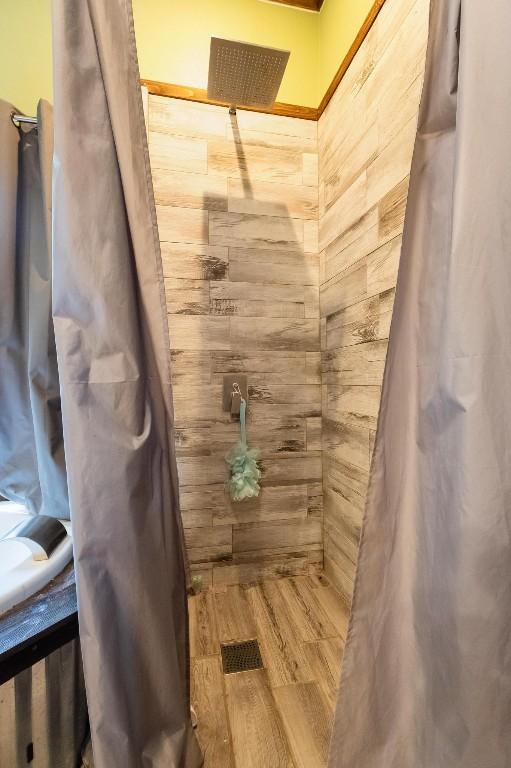 bathroom featuring hardwood / wood-style flooring and walk in shower