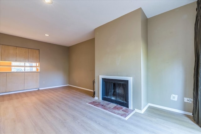 unfurnished living room with a fireplace and light hardwood / wood-style floors