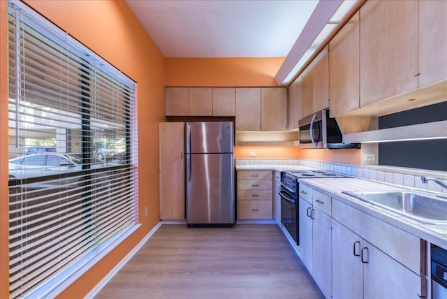 kitchen with light hardwood / wood-style floors, sink, stainless steel appliances, and light brown cabinets