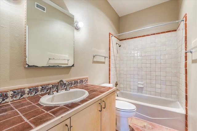 full bathroom featuring vanity, toilet, and tiled shower / bath