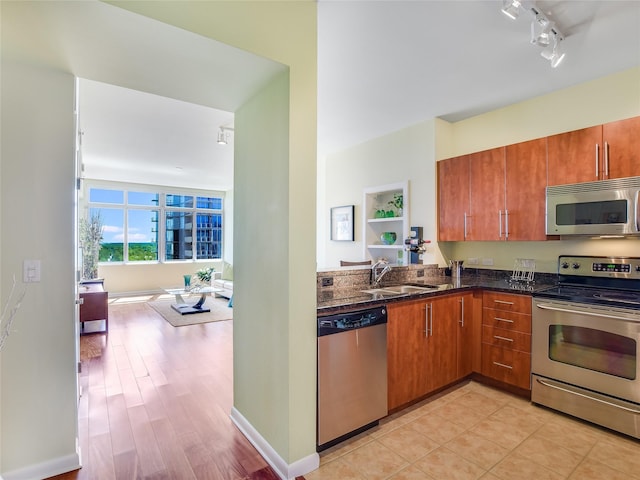 kitchen with sink, dark stone countertops, and appliances with stainless steel finishes